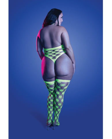 A plus-size model is shown from behind wearing a neon green and black harlequin-patterned thong and matching thigh-high stockings, set against a solid blue studio background.
