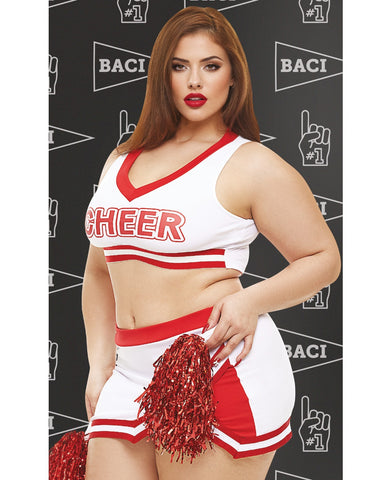 A woman modeling a white and red cheerleader costume set with red pom-poms, standing against a dark patterned backdrop with the word 'BACI' repeated.