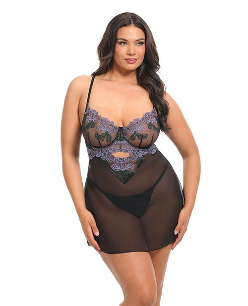 A woman modeling a sheer black lingerie with a purple and green floral lace bust, photographed against a plain white background.