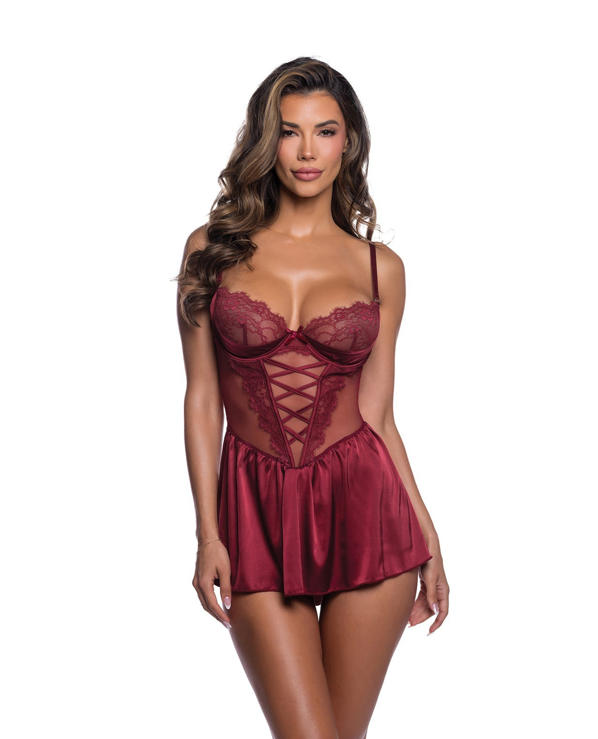 A woman modeling a burgundy satin babydoll lingerie chemise with lace cups and a lace-up corset bodice, set against a plain white background.