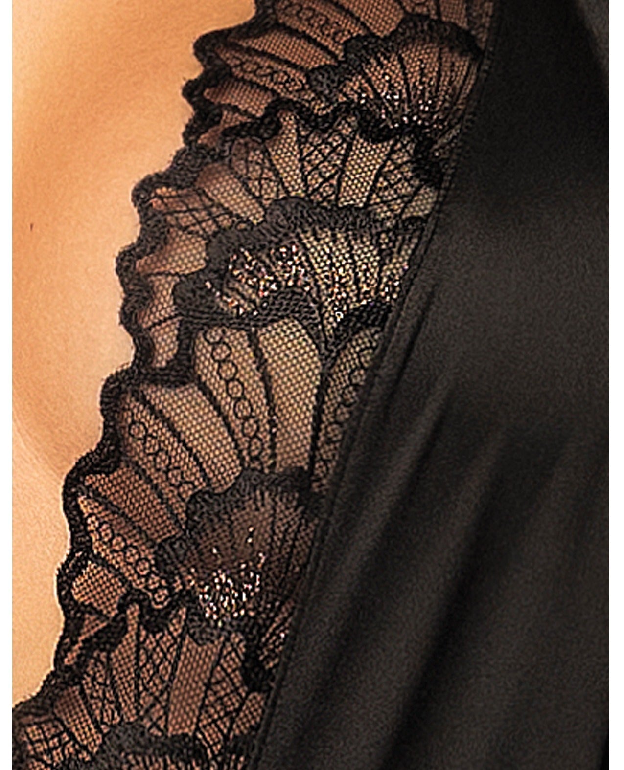 Close-up of a black lace-trimmed garment worn on a model, showing the sheer floral lace border over skin and a smooth black fabric panel.