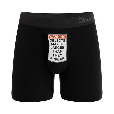 Black boxer briefs with a humorous warning label on a white background