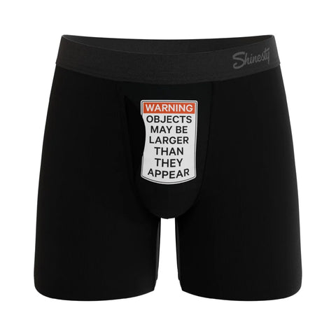 Black boxer briefs with a humorous warning label on a white background