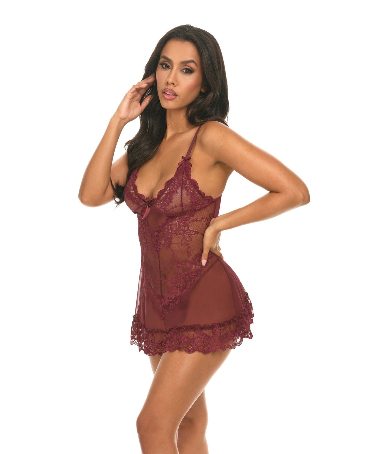 A woman modeling a sheer burgundy lace babydoll lingerie chemise against a plain white background.