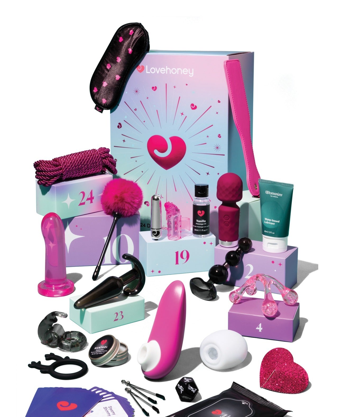 A Lovehoney branded adult gift set arranged on pastel display blocks against a white background, including a large pink and blue box, a black heart-patterned pouch, several pink and black intimate accessories, a teal tube, and small boxed items.