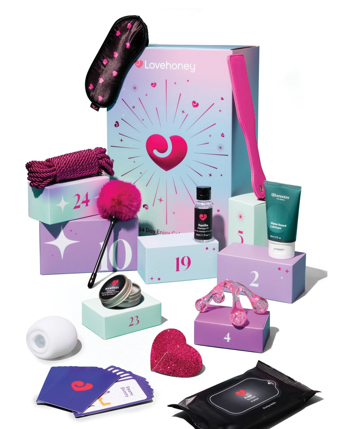Lovehoney advent kit featuring a pastel pink and purple gift box with numbered compartments, a black sleep mask with pink hearts, a pink fluffy bachelorette wand, a pink heart-shaped hair tie, a white silicone plug, a heart-shaped pink eraser, a black wet wipe packet, and other small gift items arranged on a white background.